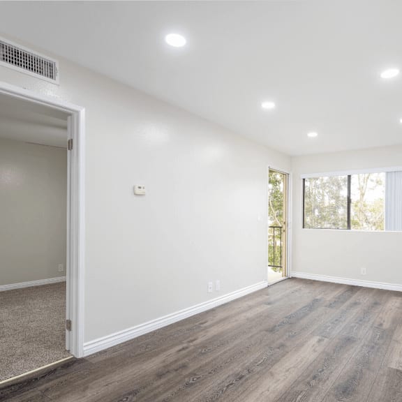 an empty living room with white walls and wood flooring at huntington terrace north senior, huntington beach, ca
