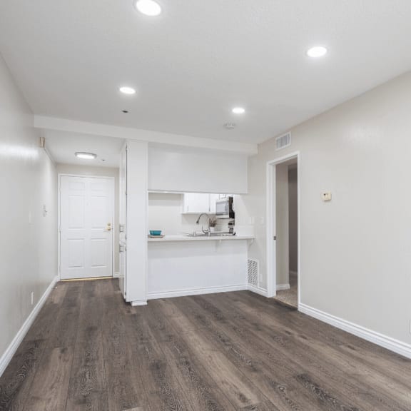 a living room and kitchen with white walls and wood flooring at huntington terrace north senior, huntington beach, ca 92648