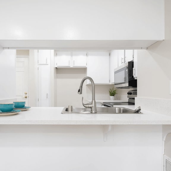 a white kitchen with a sink and a counter top at huntington terrace north senior, california