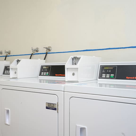 a row of washers and dryers in a laundry room at villa hemet, hemet, ca
