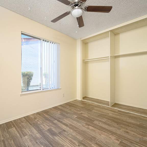 a bedroom with a large window and a ceiling fan at villa hemet, california