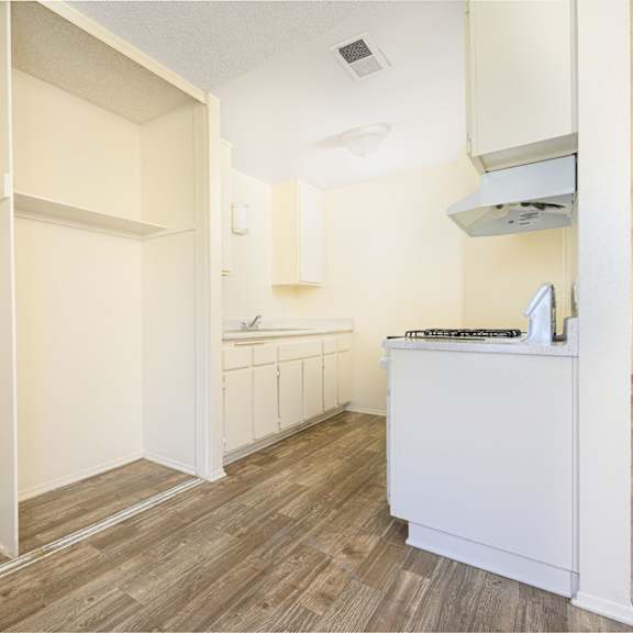 a kitchen with white walls and wood flooring at villa hemet, california