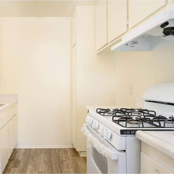 a kitchen with white cabinets and a white stove top oven at villa hemet, hemet, ca 92543