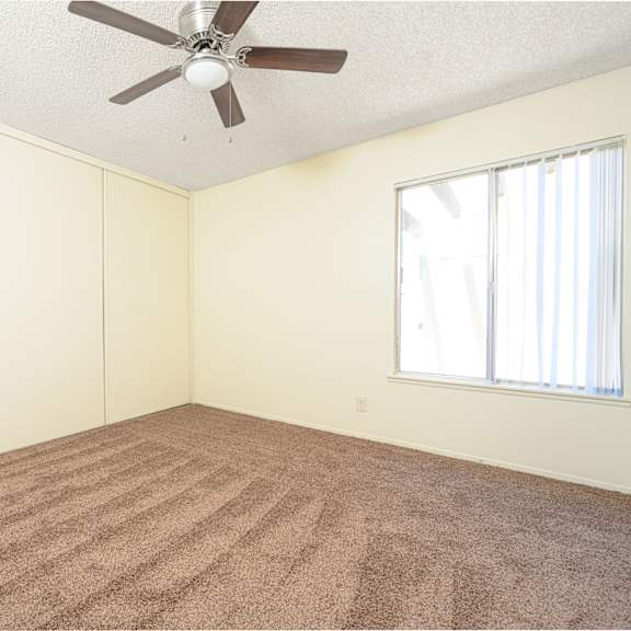 a bedroom with white walls and a ceiling fan at villa hemet, hemet, 92543