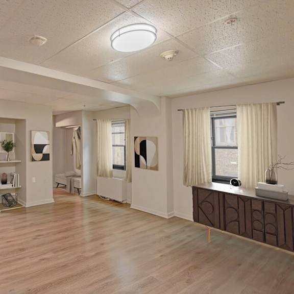 a spacious room with wooden floors and white walls.