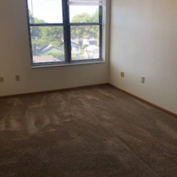 a room with a carpeted floor and a window.