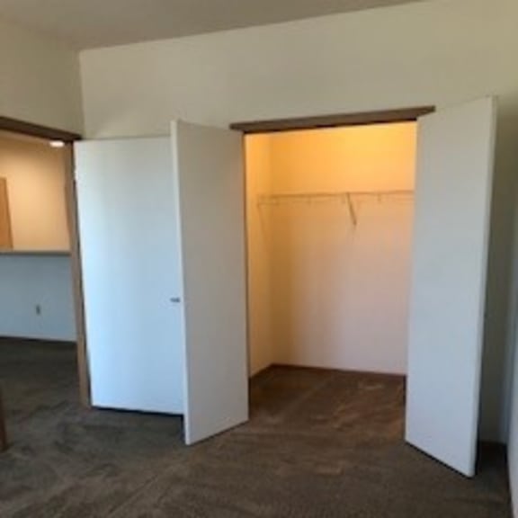 a room with a carpeted floor and a white door.