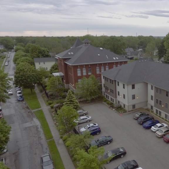 a parking lot in front of a building with cars parked.
