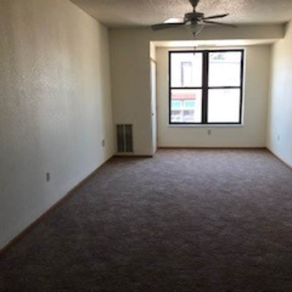 a room with a ceiling fan and a window.
