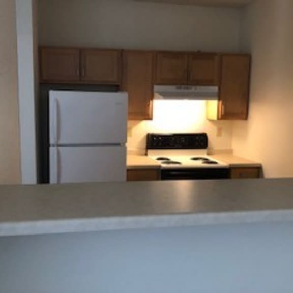 a small kitchen with a white refrigerator and a stove.