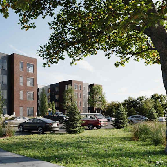 a modern apartment complex with a parking lot in front.
