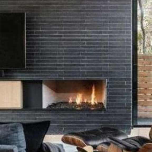 a modern fireplace with a black frame and a fire burning inside.