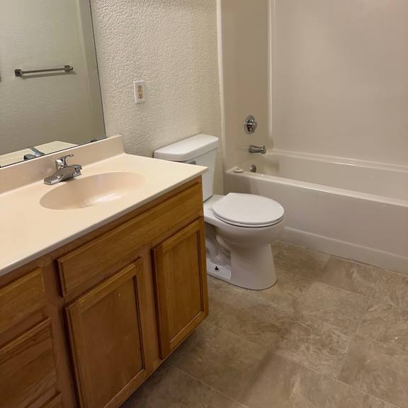 a white toilet sits next to a sink in a bathroom.