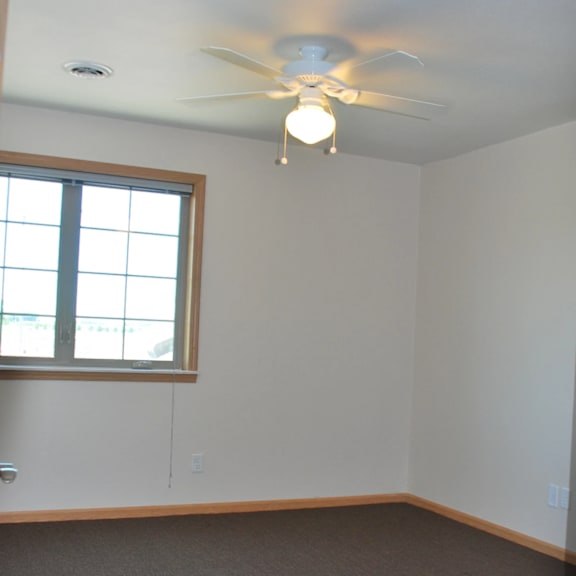 a room with a ceiling fan and a window.