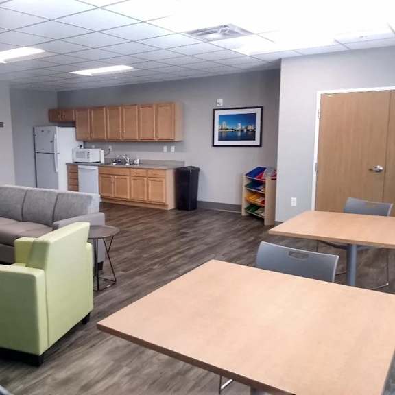 a room with a kitchenette and seating area.