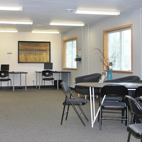 a conference room with a grey carpet and black chairs.