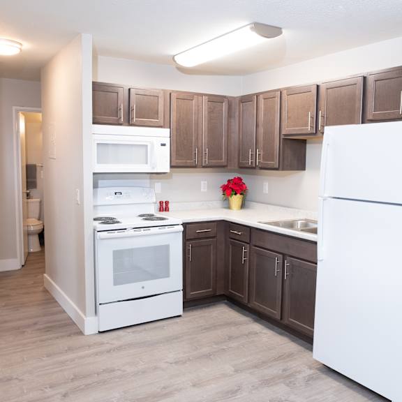 a kitchen with white appliances and brown cabinets.