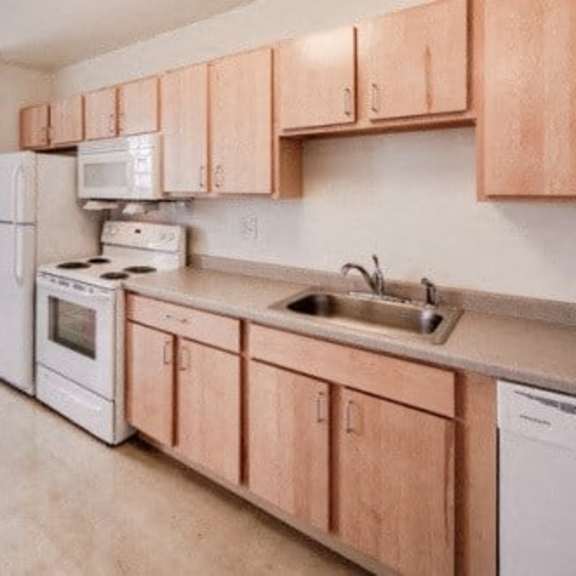 a kitchen with white appliances and wooden cabinets.