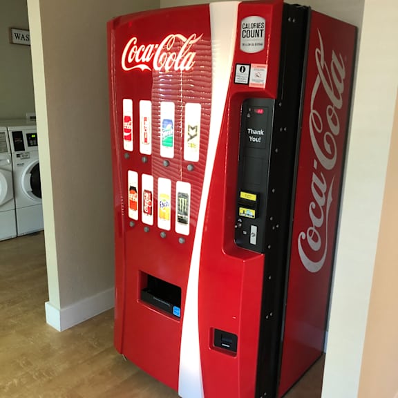 a coca-cola vending machine is on a shelf.