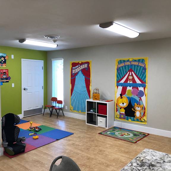 a room with a child's play area and two posters on the wall.
