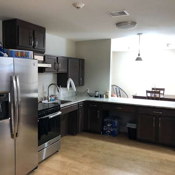 a kitchen with a stainless steel refrigerator and black cabinets.