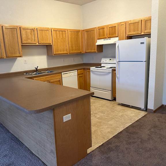 a kitchen with wooden cabinets and a white refrigerator.