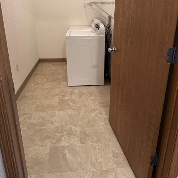 two front loading washing machines in a kitchen.