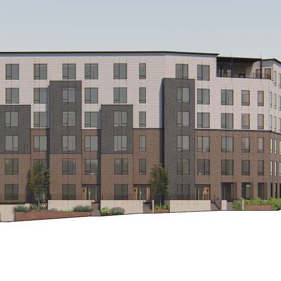 a large, modern apartment building with multiple balconies and a mix of window sizes.