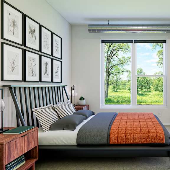 a bedroom with a bed, a potted plant, and pictures on the wall.