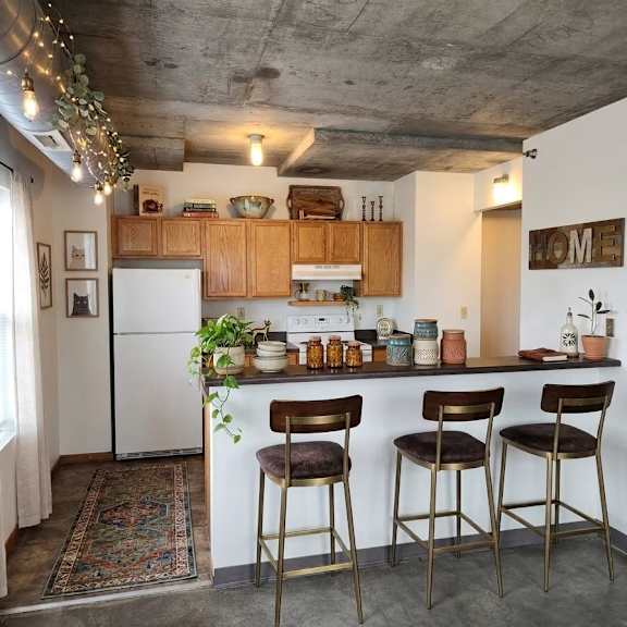 a kitchen with a white refrigerator and wooden cabinets.