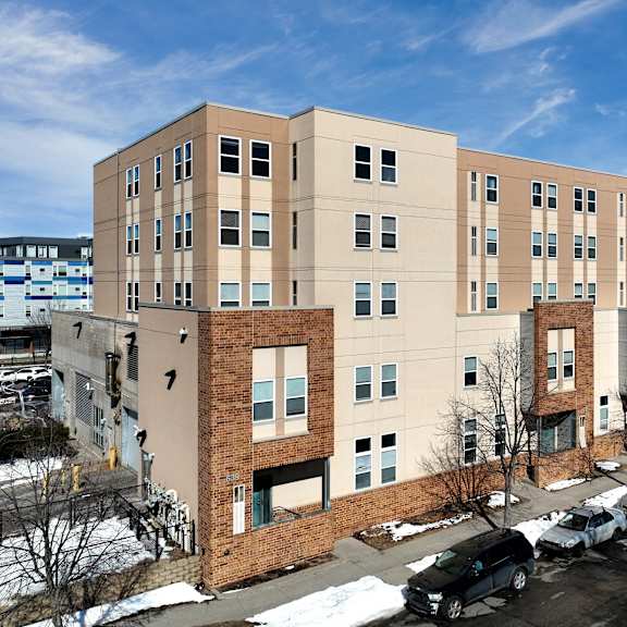a large apartment building with a parking lot in front.