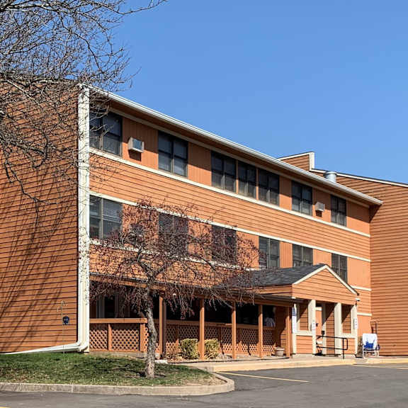 a large red brick building with a tree in front.