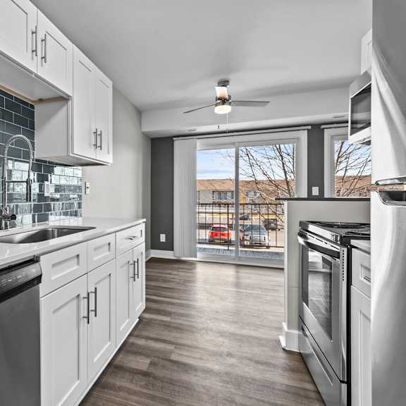 a kitchen with white cabinets and stainless steel appliances and a window at sunnymede apartments - troy, mi, troy, 48084