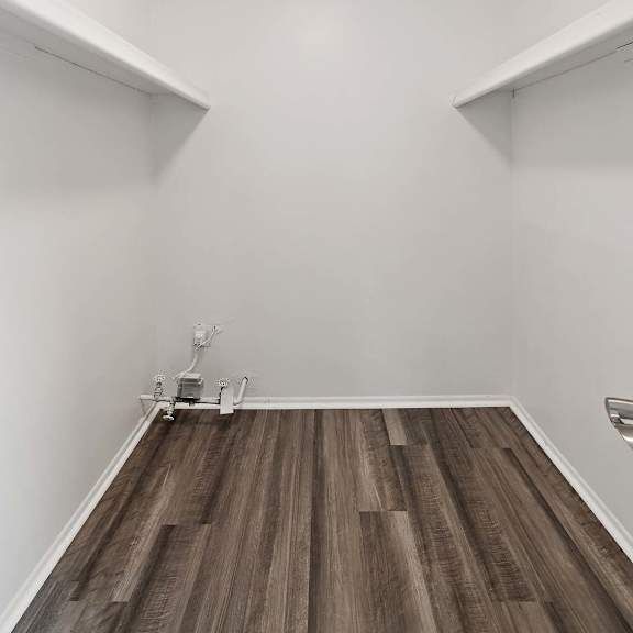 a living room with white walls and wood floors