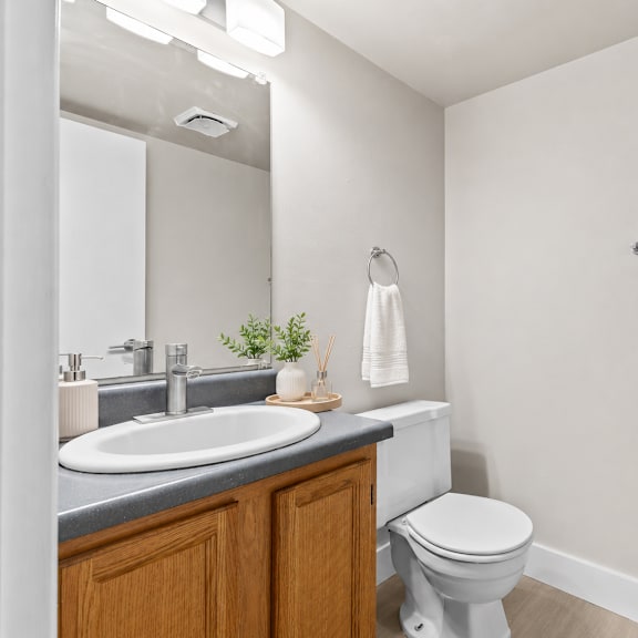 a bathroom with a toilet, sink, and towel rack.