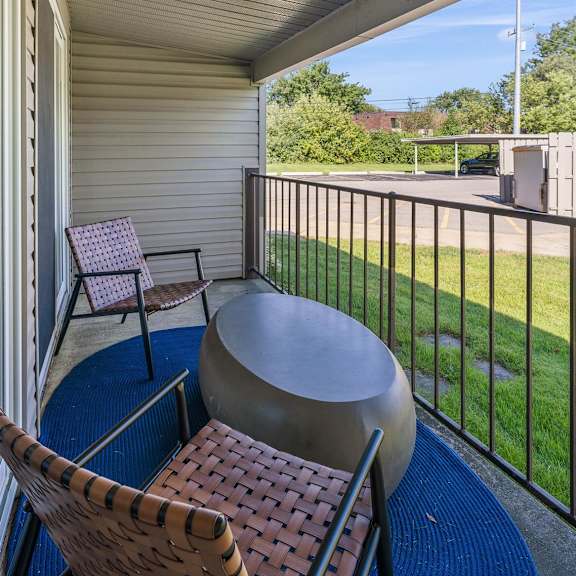 a patio with two chairs and a table on a balcony at sunnymede apartments - troy, mi, troy, 48084