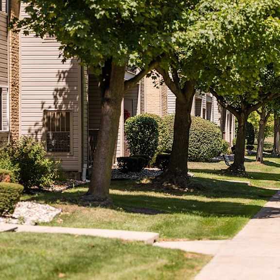 a tree lined sidewalk in front of a house at sunnymede apartments - troy, mi, troy, michigan