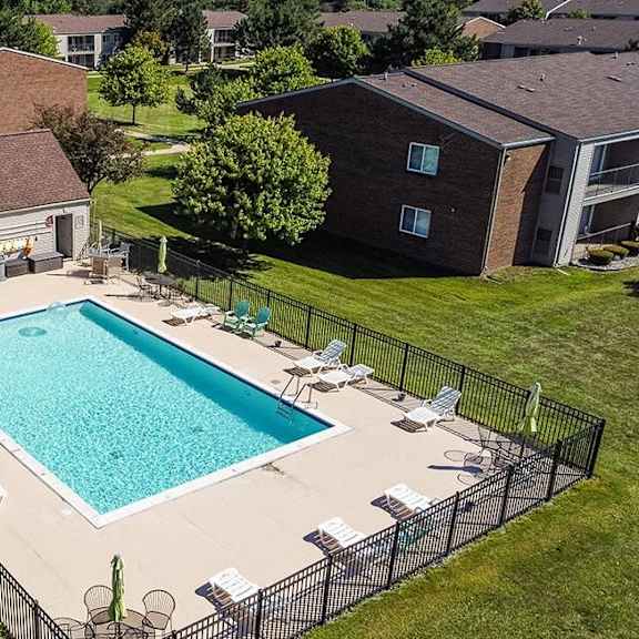 an aerial view of a swimming pool in front of a house at sunnymede apartments - troy, mi, michigan