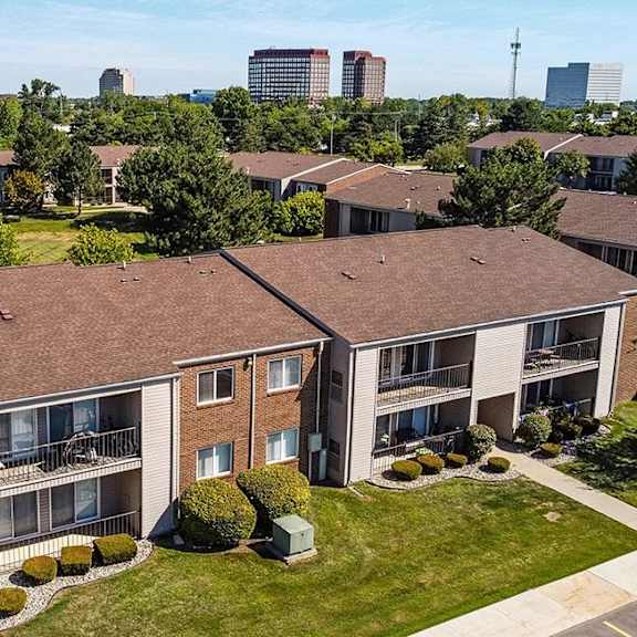 an aerial view of an apartment building with grass and trees at sunnymede apartments - troy, mi, troy, michigan
