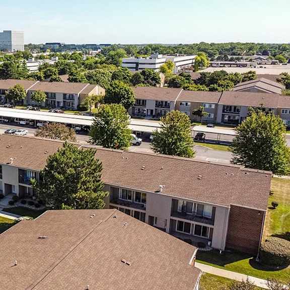 an aerial view of houses in a neighborhood with a city in the background at sunnymede apartments - troy, mi, troy