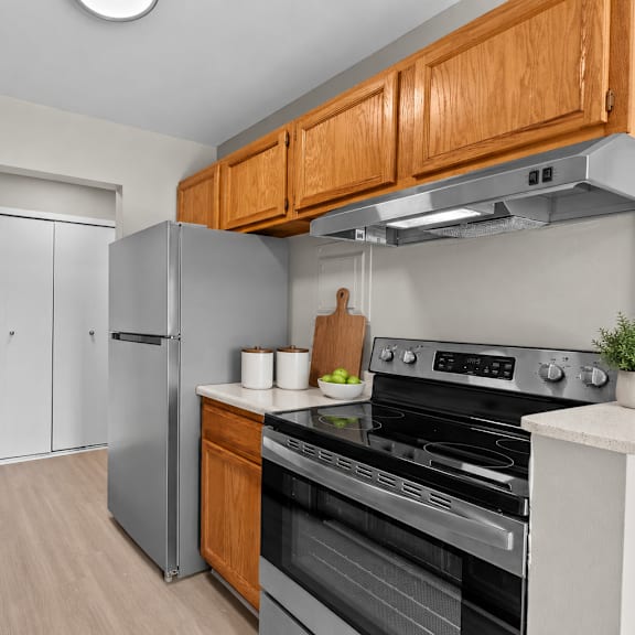a kitchen with a stove, sink, and refrigerator.