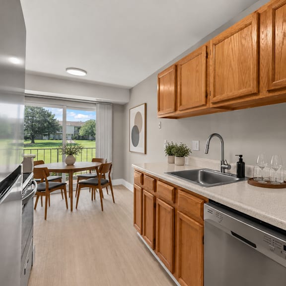 a kitchen with wooden cabinets and a stainless steel dishwasher.