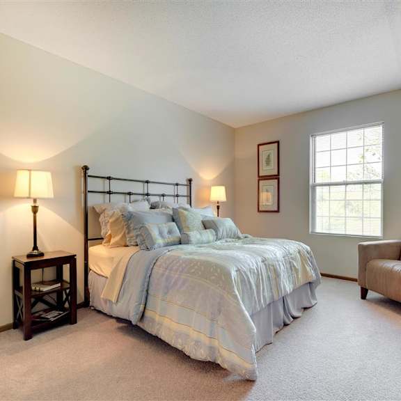 Thumbnail 4 of 7 Ridge floor plan - A bedroom with a bed, chair, and two lamps at Mallard Ridge, Maple Grove, MN