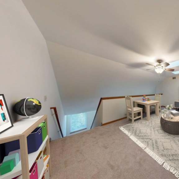 a living room with a grey sofa, a coffee table, and a television.