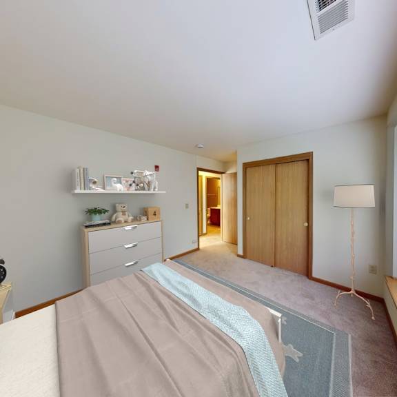 a bedroom with a bed, nightstand, and window with blinds.