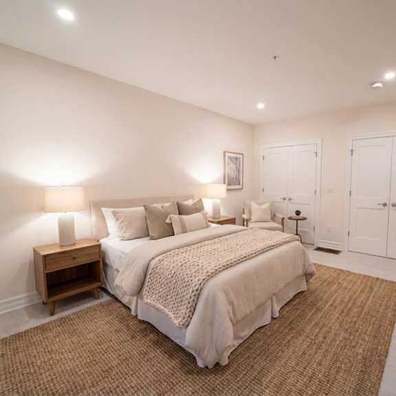 a bedroom with a bed, nightstand, and a mirror.