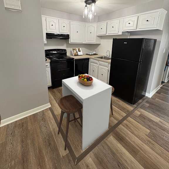 a kitchen with black appliances and white cabinets.
