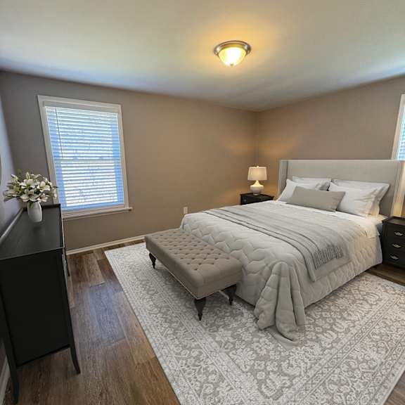 a bedroom with a large bed and a nightstand with a lamp.