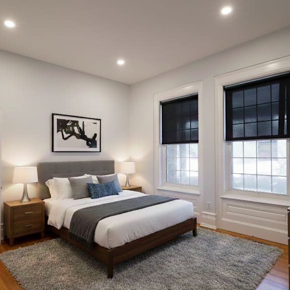 a bedroom with a bed, nightstands, and a window.