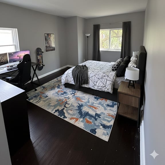 a bedroom with a bed, a window, and a rug.